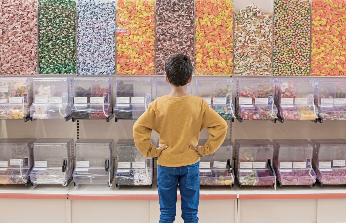 Back view of boy standing in candy store