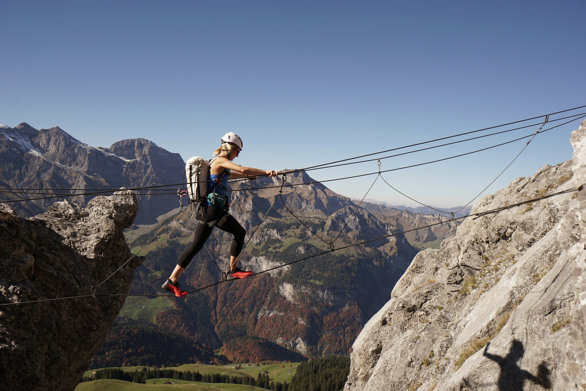 Female mountaineer ascends via ferrata route